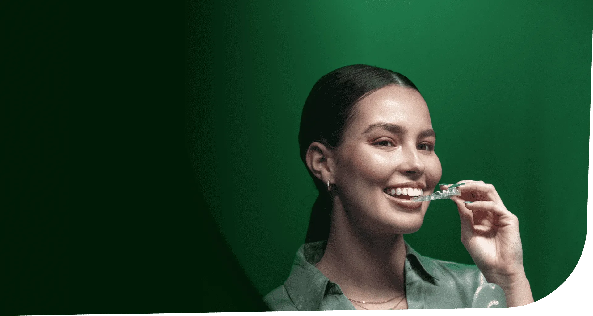 A smiling Beame customer holding her clear aligner
